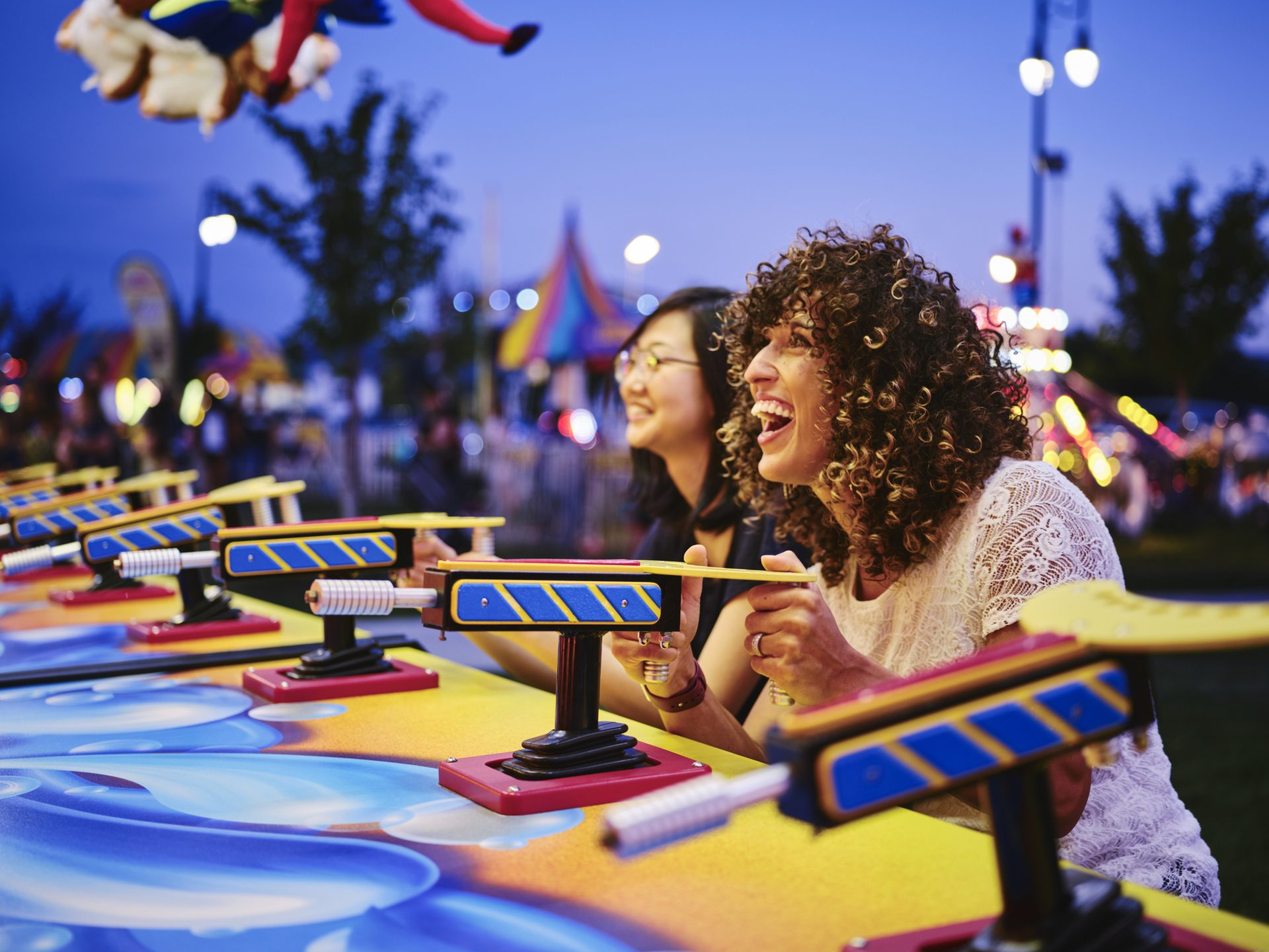 Two women playing a carnival game